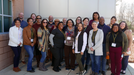 The team behind Whole Together Robeson standing outside of a steel building, posing for a group photo.